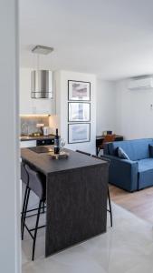 a kitchen and living room with a table and a blue couch at Studio apartment PANORAMA in Karlovac
