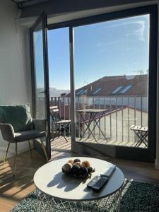 a living room with a table and a view of a balcony at Foz Douro in Porto