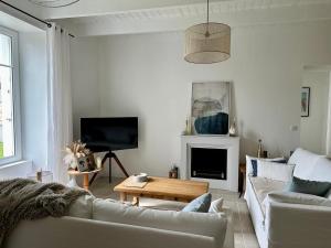 ein Wohnzimmer mit Sofa und Tisch in der Unterkunft Maison de charme 3 chambres plage de Lodonnec in Loctudy