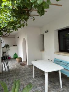 a white table and a blue bench in a room at L'Asfodelo in Uggiano la Chiesa