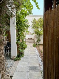 a garden with a stone pathway and a wooden fence at L'Asfodelo in Uggiano la Chiesa