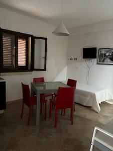 a dining room with a table and chairs and a bed at L'Asfodelo in Uggiano la Chiesa