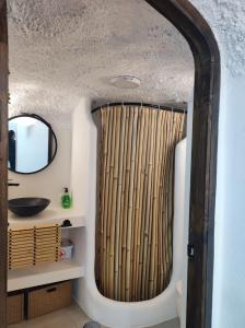 a bathroom with a shower with a bamboo curtain at Cueva Virgen de las Nieves in Monachil