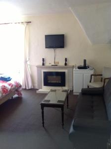 uma sala de estar com um sofá e uma lareira em The Beaufort Hunt em Chipping Sodbury