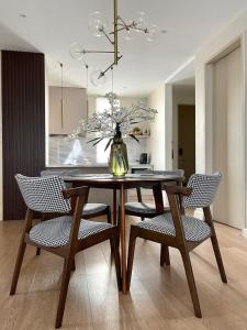 Una mesa de comedor con sillas y un jarrón con flores. en DERU Modern seaview apartment in KT city centre, en Kuala Terengganu