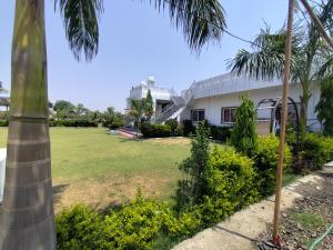 a house with a palm tree and a yard at Hotel Govindam Resort in Golāna