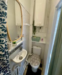 Un baño con lavabo, inodoro y espejo. en Studio tout confort proche Gare RER D, en Goussainville