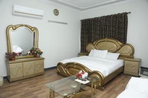 a bedroom with a bed and a mirror and a table at Marina Residency 2 in Dargai