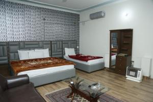 a bedroom with two beds and a mirror at Marina Residency 2 in Dargai