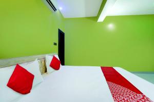 a bedroom with a bed with red and white pillows at Hotel O J.T. Residency in Rānchī