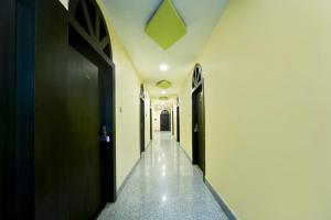 a hallway with black doors and white walls at Super Hotel O J.T. Residency in Rānchī