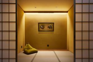 a room with a yellow pillow and a painting on a wall at Minn Nijo-jo in Kyoto +37 photos