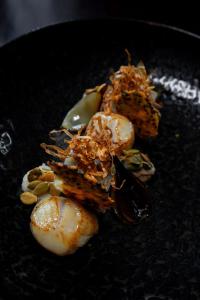 a pile of food on a black plate at Maison d'hôtes Les Notes Endormies adultes only in Walcourt +63 photos