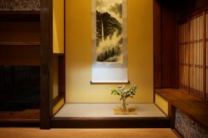 a vase of flowers sitting on a floor in a room at Minn Nijo-jo in Kyoto