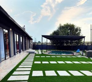 a backyard with a swimming pool and green grass at Reutlwane Gardens B&B in Secunda