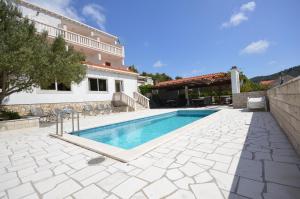 a swimming pool in front of a house at Villa Castello in Korčula