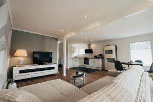 a bedroom with a large bed and a living room at Ella am See, Ferienhaus in Fintel