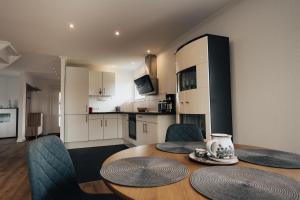 a kitchen and dining room with a table and chairs at Ella am See, Ferienhaus in Fintel