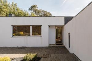 una casa bianca con una porta e una finestra di Casa Do Golf Ponte de Lima a Ponte de Lima