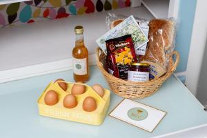 een mand met eieren en een fles bier op een tafel bij Kirktoun Cottage in Duffus +14 foto's