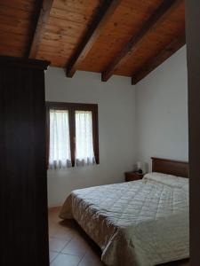 a bedroom with a bed and two windows at Da Nonna Maria Ozieri in Ozieri