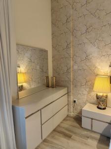 uma sala de vestir com um espelho e uma cómoda em Luxury 2 BD, A Midtown Quintessential Community em Sabkhah mais 34 fotografias