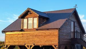 a large wooden house with a gambrel roof at The Lodge in Prickwillow