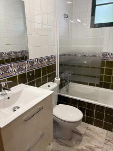 a bathroom with a toilet and a sink and a tub at Cabaña familiar in Celanova