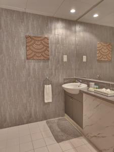 um banheiro com uma pia e um espelho em Luxury 2 BD, A Midtown Quintessential Community em Sabkhah