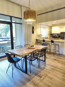 uma sala de jantar com uma grande mesa de madeira e cadeiras em Luxury 2 BD, A Midtown Quintessential Community em Sabkhah