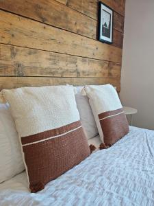 a bed with two pillows and a wooden headboard at Draycote House in Kings Lynn
