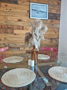 a glass table with two chairs and a vase with flowers at Draycote House in Kings Lynn