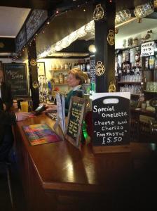 uma mulher sentada num balcão num bar em The Beaufort Hunt em Chipping Sodbury
