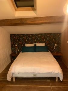 a bedroom with a large bed with green pillows at Le refuge du Jardinier in Abzac +24 photos