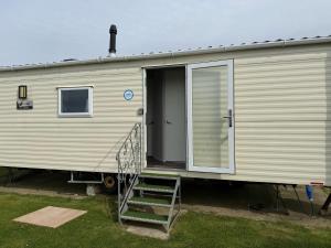 an open door of a mobile home with a ramp at Glenlea in Selsey