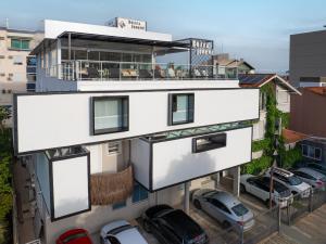 Un edificio blanco con coches aparcados en un estacionamiento. en Bossa Jurerê Hotel, en Florianópolis