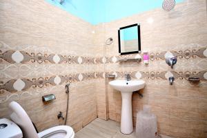 a bathroom with a sink and a toilet and a mirror at Hotel Dev Bhoomi Inn in Rishīkesh +38 photos