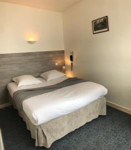 a bedroom with a large bed in a room at Hôtel Le petit billot in Vitré +4 photos
