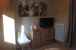 a living room with a television on a wooden dresser at AgliChalet Bosco-Vasca idromassaggio privata, condivisa tra i due chalet, con parcheggio privato gratuito e colonnina ricarica auto veloce con supplemento in Domodossola