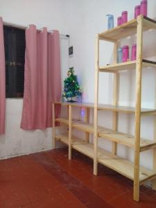 a christmas tree on a shelf in a room at Quarto e Cozinha em Mongaguá in Mongaguá +2 photos