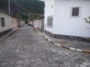 an empty street next to a white building at Quarto e Cozinha em Mongaguá in Mongaguá