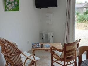 a living room with a table and chairs and a television at Studio moderne avec WiFi et parking à Baignes - FR-1-653-270 in Baignes-Sainte-Radegonde