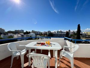a white table and chairs on a balcony at Vilamoura Design 2 by Homing in Vilamoura