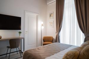 a hotel room with a bed and a desk and a window at Monteroduni 22 - Chiaia Design Rooms in Naples