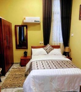 a bedroom with a large white bed and a mirror at Nouvelle Place in Trofwi