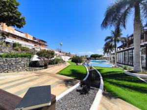 a park with palm trees and a swimming pool at RenTenerife Magec Swing & Sun Amarilla Golf in San Miguel de Abona