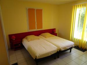 a bedroom with a bed with two pillows on it at Locatlantique in Aytré