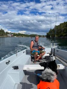 a man sitting on the back of a boat on the water at Draget gård, idyllisk småbruk ved sjøen in Molde +43 photos
