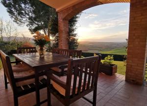 a wooden table and chairs on a patio at Villa Giulia, a splendid farmhouse in the Marche region in Appignano