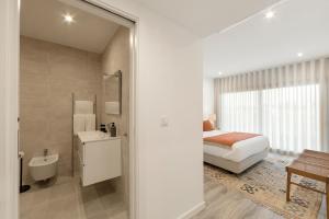 una camera da letto con un letto e un bagno di Casa LukStian a Nazaré